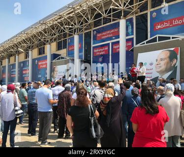Kairo, Ägypten - 14 2021. August: Ägyptische Bürger auf der Messe warten auf den Erhalt des Covid-19-Coronavirus-Impfstoffs, mit zwei der Organisatoren und Hintergrund des ägyptischen Präsidenten Stockfoto
