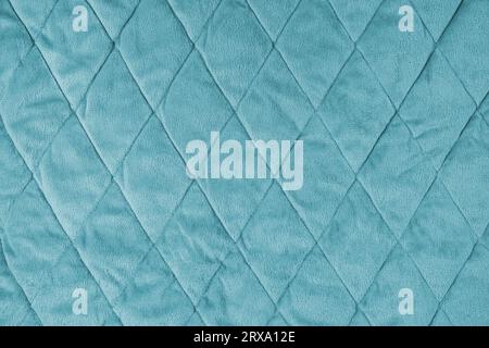 Hintergrund aus gestepptem Velours. Türkisfarbene Textur Decke oder Pufferjacke, mit Rautenmuster, weich zerknitterte Oberfläche, gekräuseltes Textil Stockfoto