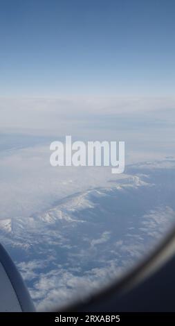Flugzeugschuss, Flug über Berge mit Wolken über europa, Reiseinhalt Stockfoto