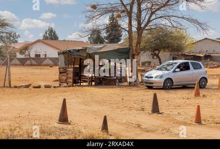 afrikanische Township eine Fahrschule, die vor der Hütte eines Straßenhändlers auf einer unbefestigten Straße in der Stadt betrieben wird Stockfoto