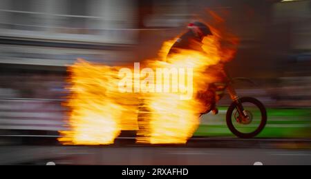 Motion Blur zeigt die Geschwindigkeit Eines Mitglieds des Rockets Childrens Motorcycle Display Team, das auf Einem Motorrad durch Flammen springt, Ringwood Carnival, Ring Stockfoto