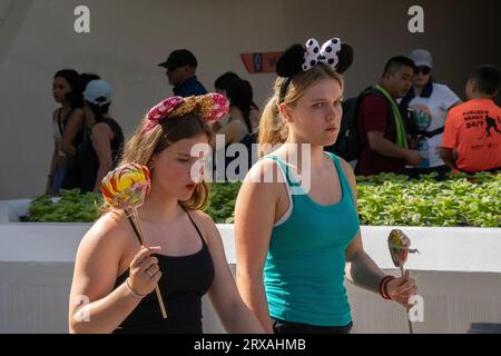 Orlando, USA - 25. Juli 2023: Zwei junge Frauen mit Disney-Stirnband im Disney World Magic Kingdom. Stockfoto