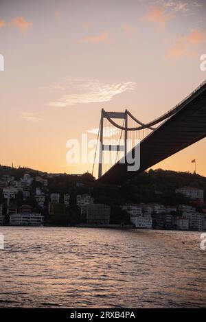 Blick auf die Brücke von unten, vorbei am Boot am Abend bei Sonnenuntergang. Istanbul. Türkei Stockfoto