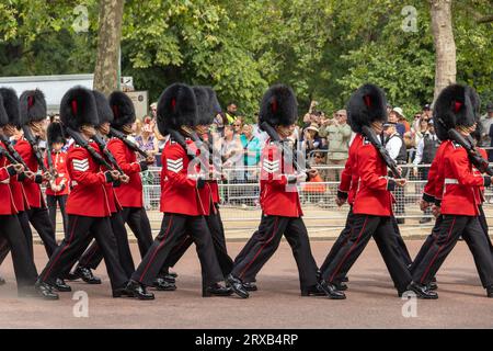 Juni, König Charles Geburtstag, Trooping the Colour Parade. Königliche Wachen mit Bärenfellmützen, die während der Parade marschieren. Umstehende beobachten. Stockfoto