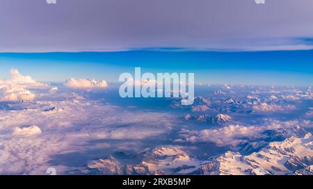 Luftaufnahme von einer dünnen Schicht von Monsun Wolken über die schneebedeckten Gipfel der Dhauladhar/Weiße Palette von Lesser Himalaya in Indien. Stockfoto