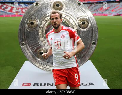 München, Deutschland 24. September 2023: Fussball, Herren, Bundesliga, Saison 2023/2024, FC Bayern München! Achtung Fotomontage ! Hier im Bild Harry Kane (FC Bayern München), Kopf, Oberkörper, im Hintergrund die aufgestellte Meisterschale, Symbolbild Stockfoto