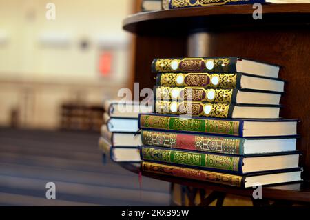 Heilige Koran Bücher in einer Reihe auf einem hölzernen Regal in einer Moschee, englische Übersetzung des Arabischen Textes (der Heilige edle Koran), es ist die zentrale Stockfoto