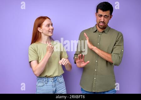 Schöne junge rothaarige Frau bittet den Mann zu arbeiten, aber fauler Ehemann sagt, dass er heute nicht arbeiten will, faules Paar plaudert hav Stockfoto