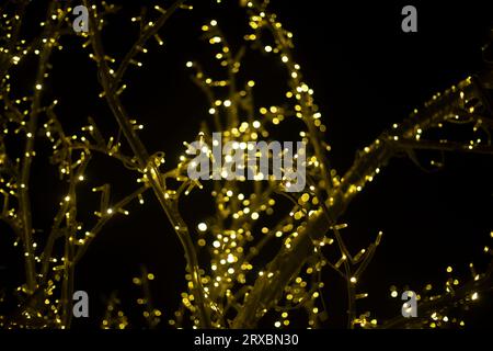 Girlanden im Dunkeln. Baum aus Glühbirnen. Heller Hintergrund. Lichter bei Nacht. Stockfoto