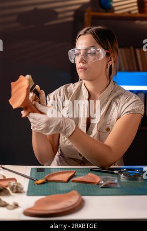 Schöne Archäologin, die spät in der Nacht im Büro arbeitet Stockfoto