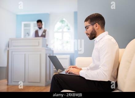 Der Reisende aus dem Nahen Osten arbeitet am Computer in der Hotellobby Stockfoto