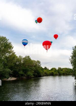 Heißluftballons über Bäumen und Boise River Stockfoto