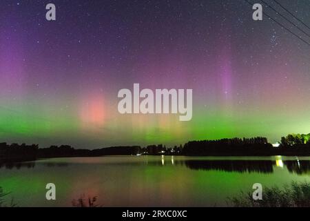 Nachtbild einer riesigen, mehrfarbigen, grünen, leuchtenden Aurora Borealis, Aurora Polaris, auch bekannt als die Nordlichter am Nachthimmel über einem See, L Stockfoto