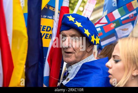 London, Großbritannien. 23. September 2023: Ein älterer Anti-Brexit-Aktivist ist beim EU National Remjoin March im Zentrum Londons von bunten europäischen Flaggen umgeben. Stockfoto