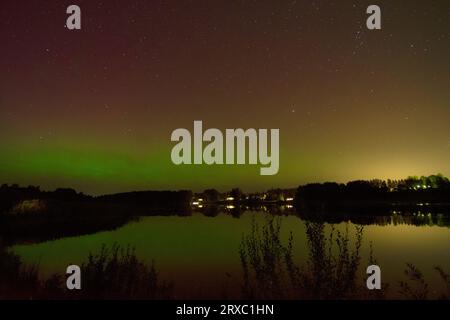 Nachtbild einer riesigen, mehrfarbigen, grünen, leuchtenden Aurora Borealis, Aurora Polaris, auch bekannt als die Nordlichter am Nachthimmel über einem See, L Stockfoto