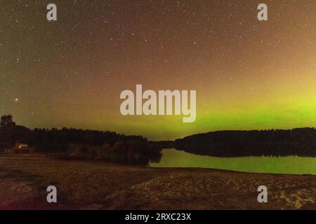 Nachtbild einer riesigen, mehrfarbigen, grünen, leuchtenden Aurora Borealis, Aurora Polaris, auch bekannt als die Nordlichter am Nachthimmel über einem See, L Stockfoto