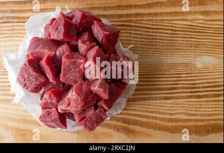 Rindfleischwürfel auf Holzbrett, kleine Jungen Stockfoto