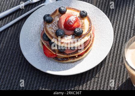 Zum Frühstück bietet die schottische Küche köstliche Pfannkuchen mit verschiedenen Beeren und Saucen. Stockfoto