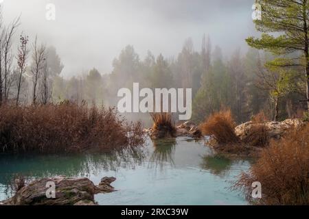 Nebellandschaft bei Sonnenaufgang in einem der Teiche des Chorreras del Río Cabriel in Enguídanos, Cuenca, Spanien Stockfoto