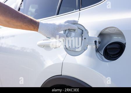 Der Fahrer öffnet die Klappe des Gastanks. Öffnen Sie den Gastank von Hand. Hochwertige Fotos Stockfoto