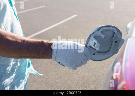 Der Fahrer öffnet die Klappe des Gastanks. Öffnen Sie den Gastank von Hand Stockfoto