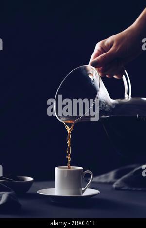 Kaffee mit einem Filtertropfer zubereiten. Kaffee tropft durch einen Papierfilter. Alternative Möglichkeit, Kaffee zuzubereiten. Stockfoto