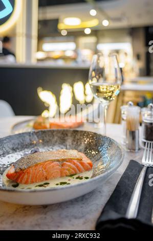 Lachsfilet in Sahnesauce mit Kräutern auf einem Marmortisch in einem Restaurant. Hochwertige Fotos Stockfoto