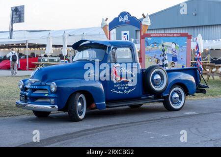 September 2023: Der Blue American Pick-up-Truck sammelte während des Goodwood Revival-Renntreffens defekte Motorräder von der Rennstrecke. Stockfoto