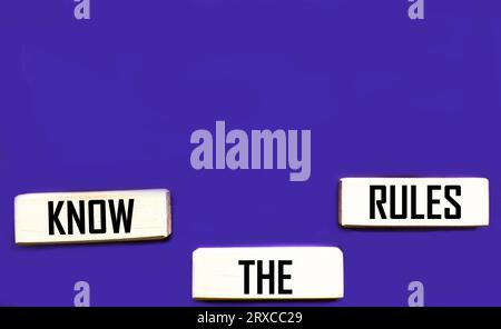Holzwürfel mit Wörtern kennen die Regeln. Schöner lila Hintergrund. Business und Kenntnisse des Regelkonzepts. Leerzeichen kopieren. Stockfoto