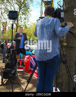 Eine TV-Crew, die ein Stück zur Kamera bei der Königskrönung in der Mall aufbaut. Der Reporter trägt kurze Hosen in seinem Anzug. Stockfoto