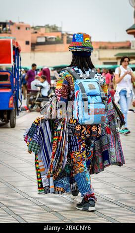 Marrakesch, Marokko, 8. April 2023. Rückansicht eines marokkanischen Verkäufers, der bunte Kleidung auf dem Marrakesch Jemaa el-Fnaa-Platz verkauft. Stockfoto