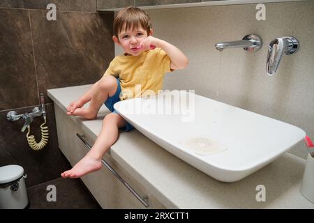 Kleiner kleiner Junge, der im Badezimmer die Zähne putzt. Kind im Alter von zwei Jahren (zweijähriger Junge) Hygienekonzept. Stockfoto