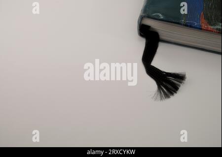 Schwarzes Farbband als Lesezeichen auf grauem Hintergrund Stockfoto