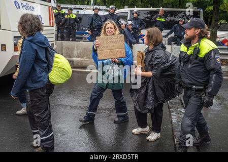 Den Haag, Niederlande. September 2023. Eine Aktivistin wird von der Polizei zu einem Wartebus begleitet, der sie während der gewaltfreien Sitzdemonstration zum ADO-Fußballstadion bringt. Die heutige gewaltfreie Demo auf der Utrechtsebaan war der 15. Tag der A12-Protestblockade in den Haag. Die Polizei verhaftete am Samstag 552 Aktivisten, die die A12 in den Haag teilweise blockierten, 200 wurden gestern verhaftet. Die Demonstrationen der Extinction Rebellion haben nun zum fünfzehnten Tag in Folge die Haupteingangsstraße zur A12 blockiert und fordern, dass die Regierung die Unterstützung einstellt Stockfoto