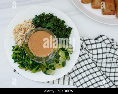 Pecel Sayur oder gemischtes gedämpftes Gemüse mit Erdnusssoße. Traditionelle Speisen aus Zentral-Java oder Ost-Java, Indonesien Stockfoto