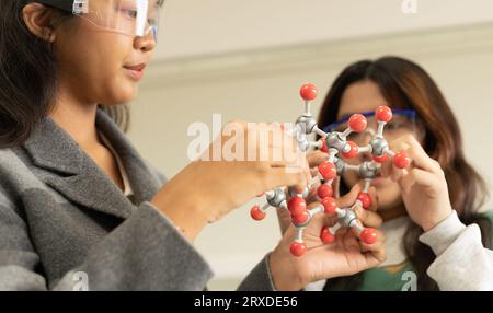 MINT-Bildungskonzept. Asiatische Kinder in der Laborforschung eine Experimentprüfung mit dem Molekülmodell. Das neue Bildungssystem im Klassenzimmer Stockfoto