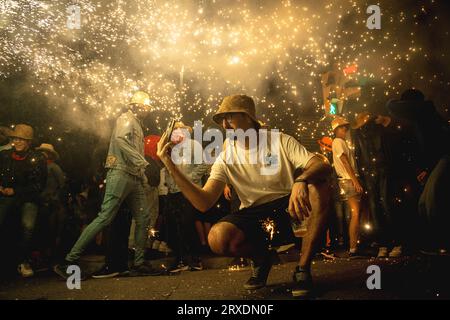Tarragona, Spanien. September 2023 25. Ein Zuschauer macht ein Foto unter dem Feuerwerk von ‚Correfocs (Feuerläufer) beim „Santa Tecla Festival“ in Tarragona. Quelle: Matthias Oesterle/Alamy Live News Stockfoto