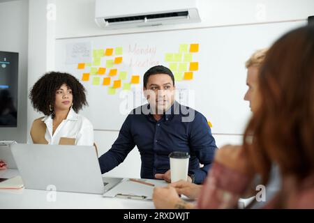 Teamleiter, der mit Entwicklern und Managern im Gespräch spricht Stockfoto