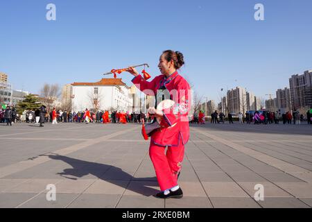 Luannan County, China - 29. Januar 2023: Die Menschen tragen bunte Kleidung und tanzen Yangko im Rhythmus auf dem Platz, Luannan County, Provinz Hebei, C Stockfoto