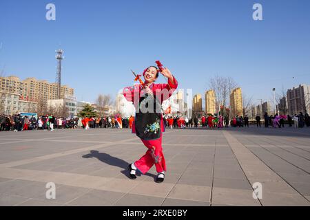 Luannan County, China - 29. Januar 2023: Die Menschen tragen bunte Kleidung und tanzen Yangko im Rhythmus auf dem Platz, Luannan County, Provinz Hebei, C Stockfoto