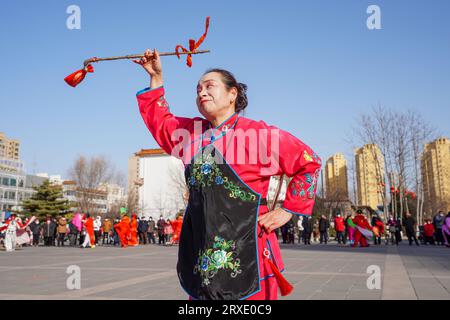 Luannan County, China - 29. Januar 2023: Die Menschen tragen bunte Kleidung und tanzen Yangko im Rhythmus auf dem Platz, Luannan County, Provinz Hebei, C Stockfoto