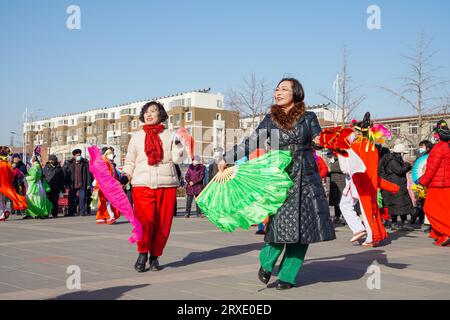 Luannan County, China - 29. Januar 2023: Die Menschen tragen bunte Kleidung und tanzen Yangko im Rhythmus auf dem Platz, Luannan County, Provinz Hebei, C Stockfoto