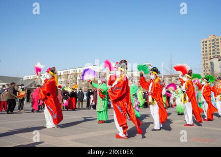 Luannan County, China - 29. Januar 2023: Die Menschen tragen bunte Kleidung und tanzen Yangko im Rhythmus auf dem Platz, Luannan County, Provinz Hebei, C Stockfoto