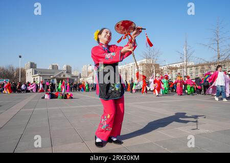 Luannan County, China - 30. Januar 2023: Die Menschen tragen bunte Kleidung und tanzen Yangko im Rhythmus auf dem Platz, Luannan County, Provinz Hebei, C Stockfoto