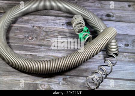 Ein gebrochener flexibler Schlauch aus einem Staubsauger, minderwertigen Materialien und Wartungskonzept, ein Staubsauger ist eine elektrische Hausmaschine Stockfoto