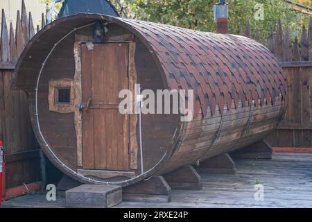 An einem sonnigen Sommertag steht im Innenhof ein rundes Holzbadehaus Stockfoto