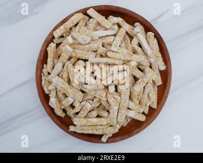 Rohes Tempo oder tempe. Orek tempeh auf einem Holzteller. tempeh aus fermentierten Sojabohnen Stockfoto