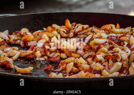 Kartoffeln werden in einer gusseisernen Pfanne gebraten und auf einem Bauernmarkt auf dem Place Broglie Square, dem historischen Zentrum von Straßburg, im Elsass, Frankreich, verkauft Stockfoto