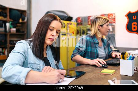 Konzentrierte Unternehmerinnen, die in einem kleinen Unternehmen arbeiten, um über Online-E-Commerce zu verkaufen Stockfoto