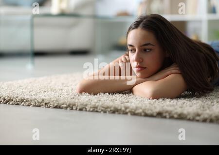 Traurige Frau, die nachts zu Hause auf dem Boden liegt Stockfoto